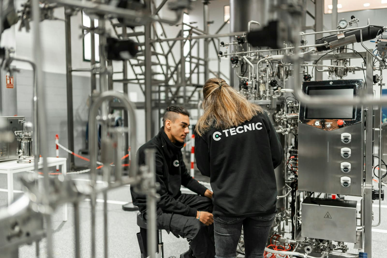 Plant technicians reviewing a stainless water-treatment skid